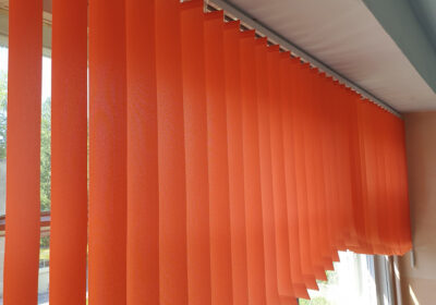 Арочные вертикальные жалюзи морковного цвета на окнах в школьном коридоре